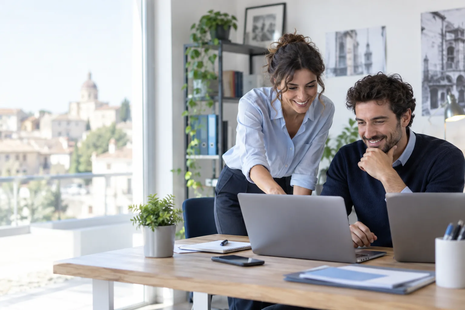 Due professionisti collaborano con i portatili in ufficio